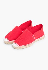 Espadrilles en toile rouge avec une semelle en rope jute plate. Présente un design simple à enfiler avec des coutures blanches le long des bords.