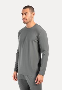 Graues Langarmshirt aus leichtem Stoff, mit Rundhalsausschnitt und glatter, gleichmäßiger Textur. Schlichtes Design ohne Muster.