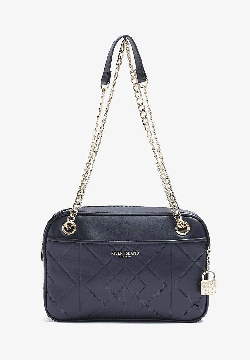 Borsa a spalla trapuntata blu navy con tracolla in catena dorata, dotata di chiusura con zip e dettaglio decorativo a forma di lucchetto. Finitura liscia e texture.