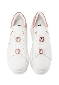 Sneaker bianchi in pelle con accenti in suede rosa, caratterizzati da intricate decorazioni in gemme sui lacci e un design liscio e arrotondato.