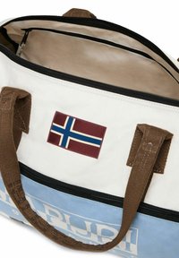 Grande borsa da viaggio in tela bianca e azzurro chiaro, con manici in tessuto marrone, chiusura a zip e una patch della bandiera norvegese.