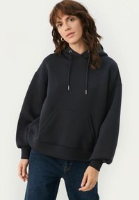 Marinblå överdimensionerad hoodie med framficka, justerbara dragkedjor och muddar; tillverkad av mjukt, strukturerat tyg för komfort.