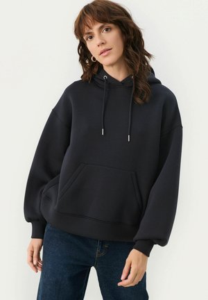 Navy oversized hoodie with a front pocket, adjustable drawstrings, and cuffed sleeves; made from soft, textured fabric for comfort.