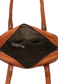 Brown leather shoulder bag open to show dark fabric interior with two small inner pockets and a label.