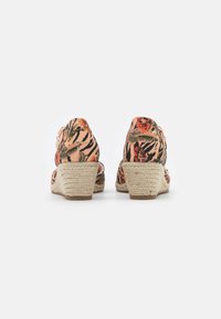 Sandalias de cuña con una parte superior de tejido estampado floral y rayas en tonos coral y verde, con un tacón de yute trenzado y diseño de espalda abierta.