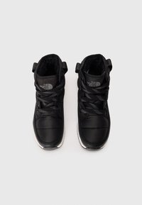 Black high-top shoes with a padded exterior, textured black laces, and a white rubber sole. Features logo on each tongue and side.