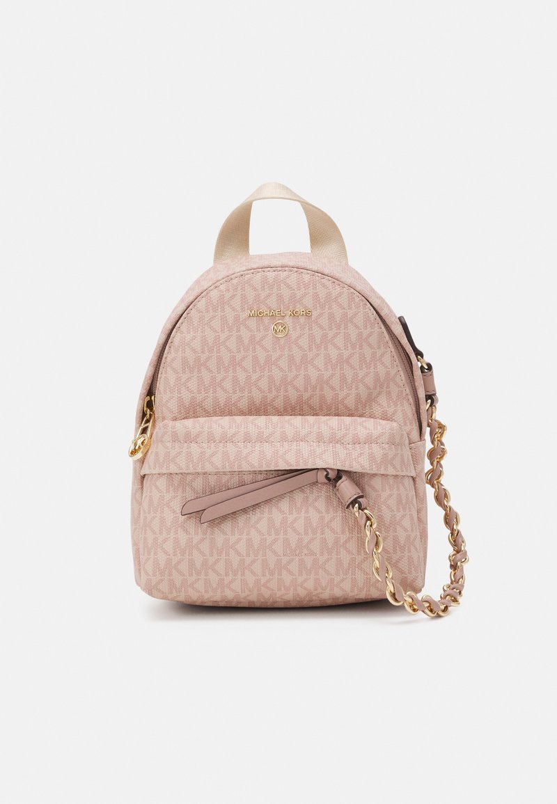Petit sac à dos rose Michael Kors avec motif logo MK, poche avant zippée, détail chaîne dorée et poignée supérieure sur fond uni.