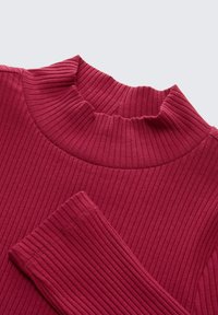 Geribde coltrui in diep rood, met een hoge kraag en lange mouwen. Gemaakt van zachte stof met een gestructureerd patroon.