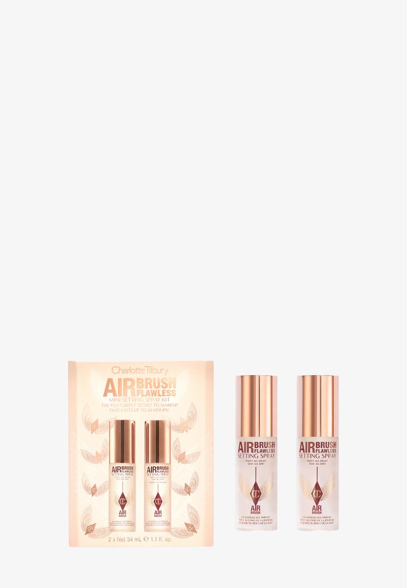 L'ensemble comprend deux flacons vaporisateurs transparents avec des caps en or, présentés dans une boîte beige ornée d'accents dorés et rouges ainsi que d'un texte sur le produit.
