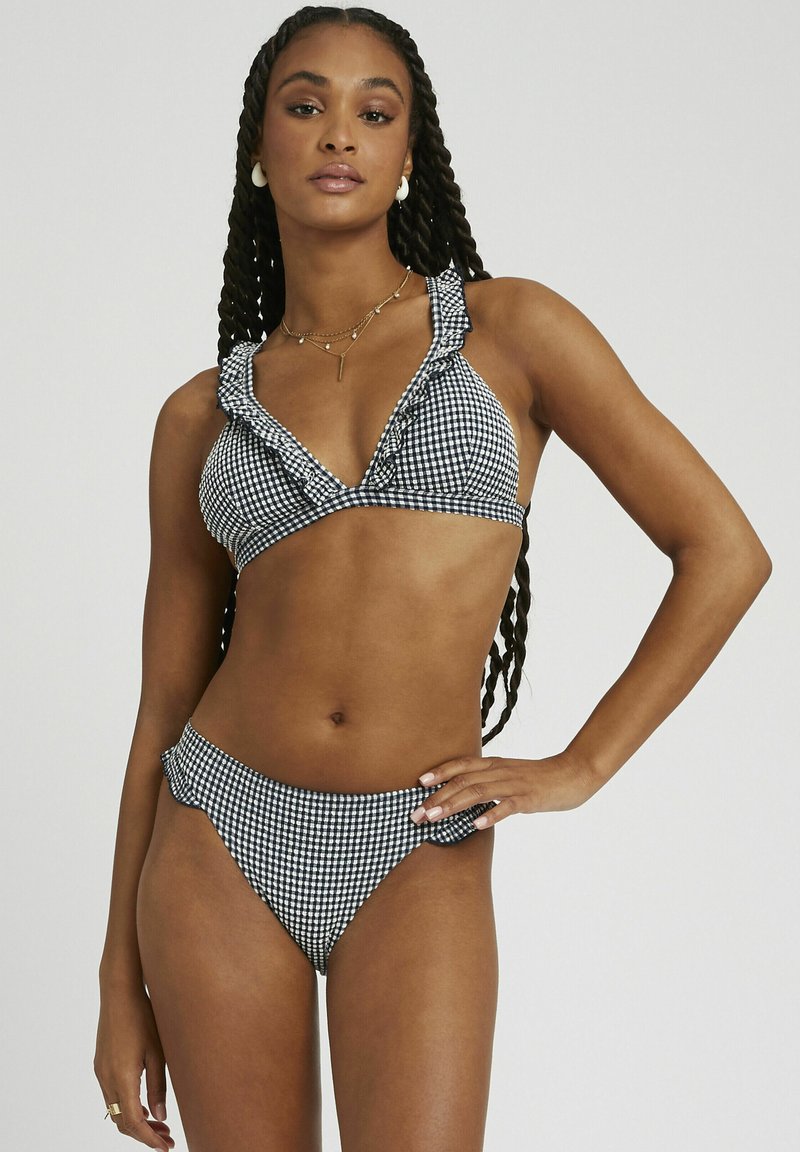 Ensemble de bikini avec un motif vichy noir et blanc, présentant des bords volantés sur le haut et le bas, fabriqué à partir d'un tissu lisse.