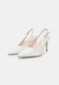 Beli usnjeni slingback petek z ostro konico, minimalistična zasnova, odprti strani, svetlo roza notranjost in ozka zlata petka.