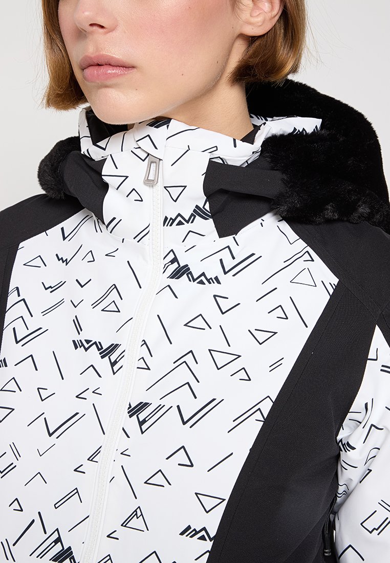 Biała i czarna kurtka z geometrycznymi wzorami, z zamkiem z przodu i kapturem wykończonym sztucznym futrem. Materiał wydaje się gładki, z kontrastującymi panelami kolorów.