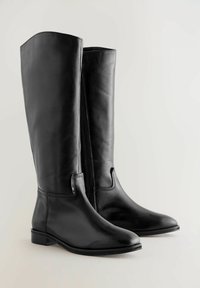 Botas de cuero negro hasta la rodilla con una textura suave, punta redonda, tacón bajo y cremallera lateral para un fácil uso; cuenta con un detalle de costura mínimo.