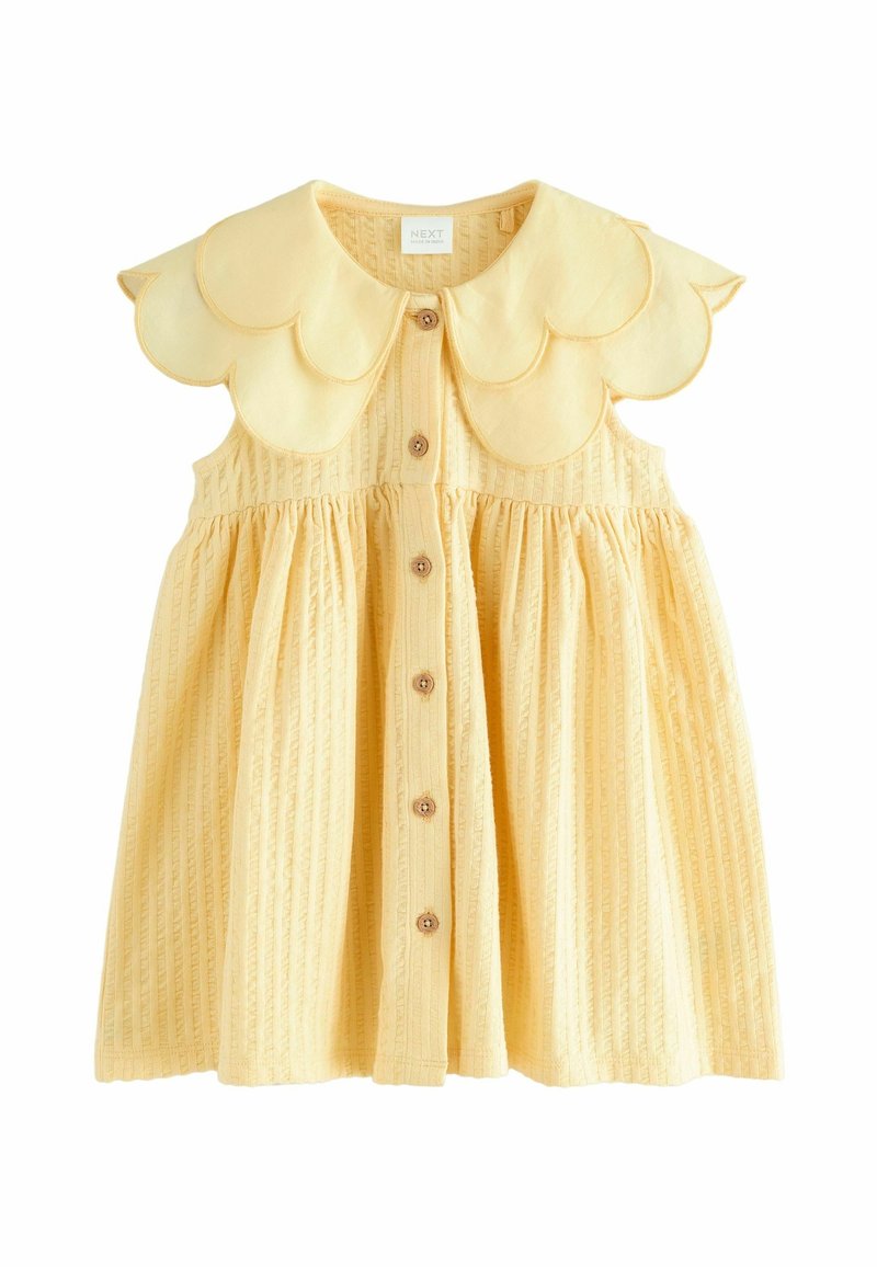 Robe bébé jaune sans manches avec col festonné, boutons en bois sur le devant et tissu texturé à rayures verticales.