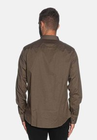 Camicia a maniche lunghe in tessuto marrone strutturato con colletto button-down, caratterizzata da un motivo sottile e vestibilità sagomata.