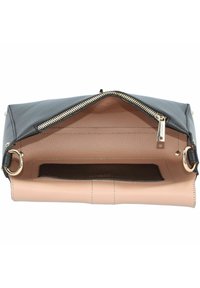 Sac en cuir noir texturé avec une fermeture éclair, intérieur beige et accent en métal doré. Comprend une poche plate à l'intérieur pour l'organisation.