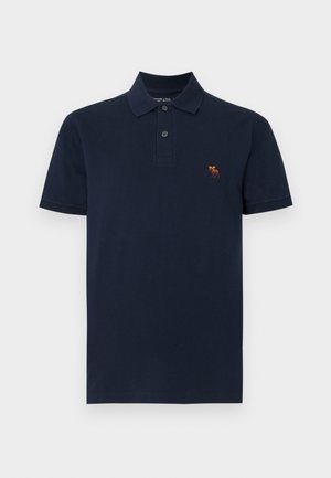 Polo bleu marine à manches courtes avec deux boutons et un petit logo d'élan orange sur la poitrine gauche.