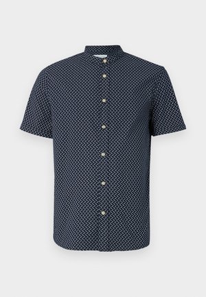Cămașă cu mânecă scurtă de culoare bleumarin, cu un model geometric alb, cu închidere cu nasturi și guler. Materialul pare ușor și are o textură netedă.