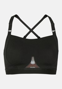 Reggiseno sportivo nero con design a incrocio, caratterizzato da un tessuto testurizzato e un accento triangolare rosso e bianco al centro davanti con logo.