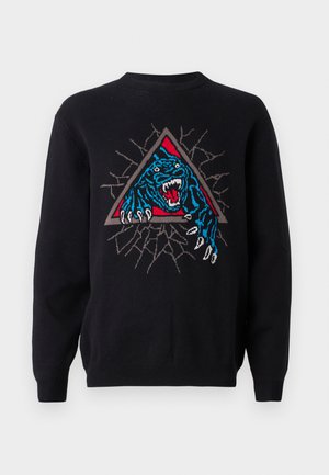 Zwarte trui met een kleurrijk geborduurd ontwerp van een brullende blauwe panter binnen een rode driehoek, tegen een gekraakt achtergrond.