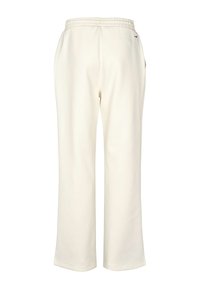 Kreemivärvilised dressipüksid elastse vöökohaga, lõdva lõikega, küljetaskutega ja väikese logodetailiga tagatasku lähedal.