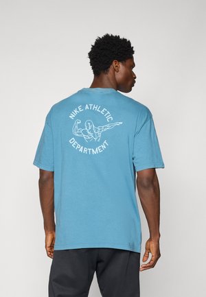 Blaues Baumwoll-T-Shirt mit einem grafischen Druck auf der Rückseite, der "Nike Athletic Department" zeigt, zusammen mit einer Illustration einer muskulösen Figur.