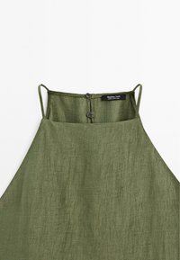 Robe en lin sans manches vert olive avec fines bretelles et deux boutons noirs à la fermeture arrière, avec une étiquette Massimo Dutti.