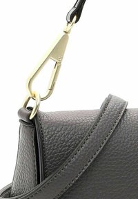 Grijze leren tas met een gekorrelde textuur, voorzien van een goudkleurige sluiting en hardware, en een platte schouderband met zichtbare stiksels.