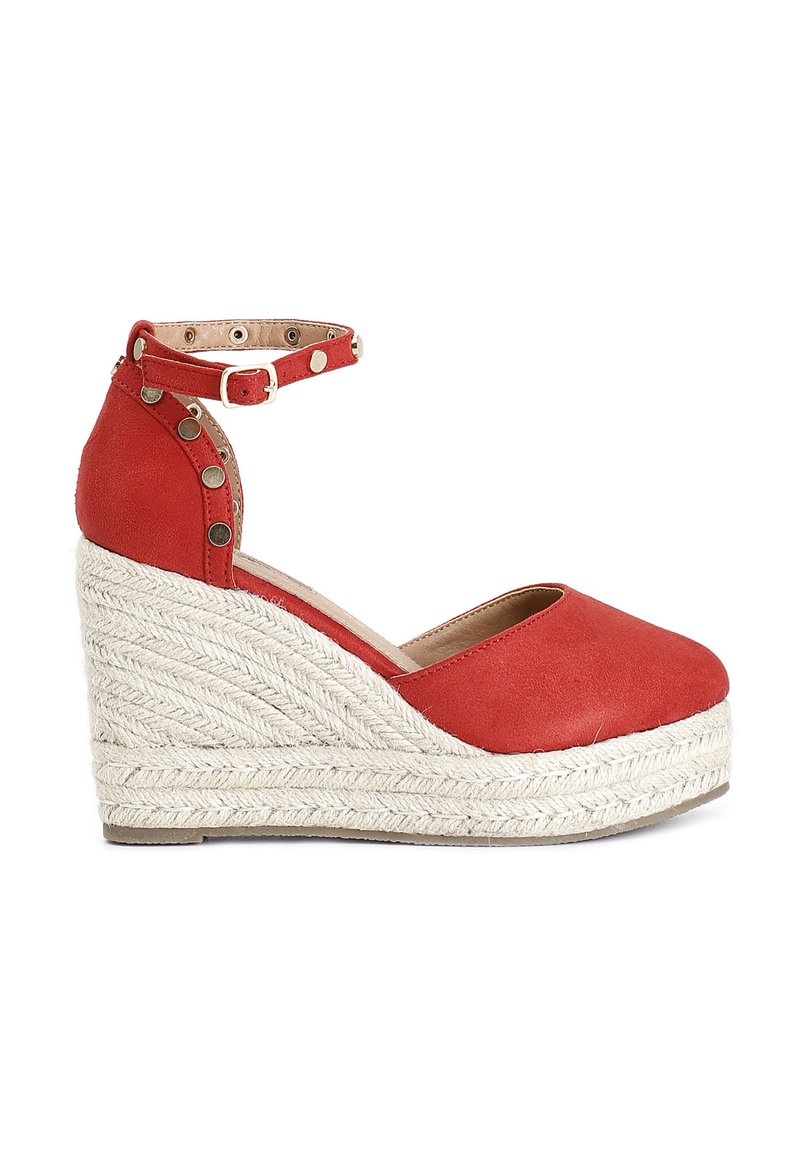 Sandalo con zeppa in suede rosso, piattaforma in juta intrecciata, cinturino alla caviglia con borchie metalliche e design della punta arrotondato. Altezza approssimativa di 10 cm.