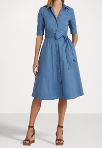 Himmelblaues Hemdkleid mit Kragen, kurzen Ärmeln und einem gebundenen Taillengürtel; ausgestellter Rock, glattes Baumwollmaterial und knielang.