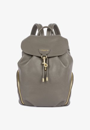 Sac à dos en cuir gris avec rabat, fermoir en or, zips latéraux et double bretelles.