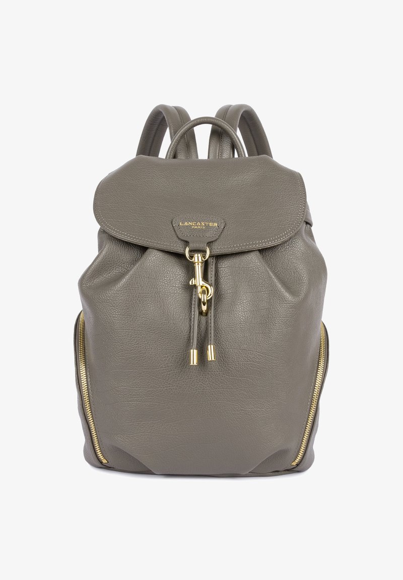 Sac à dos en cuir gris avec rabat, fermoir en or, zips latéraux et double bretelles.