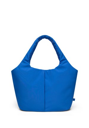 Sininen pehmeä kangaskassi leveillä pehmustetuilla kahvoilla ja yksinkertaisella, koristelemattomalla designilla valkoista taustaa vasten.