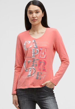 Langärmliges, korallenfarbenes Shirt mit V-Ausschnitt, verziert mit gemischten Textgrafiken und einem leicht abgerundeten Saum. Hergestellt aus weichem, leichtem Stoff.