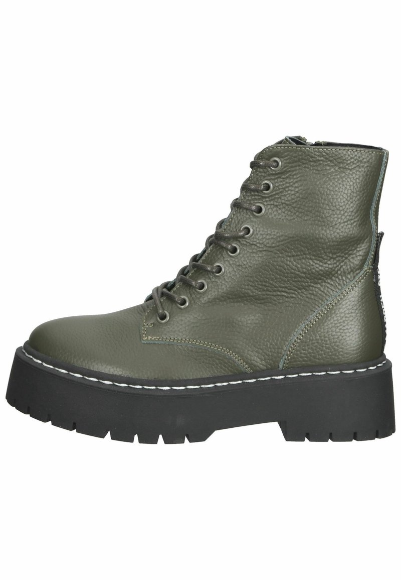Botte de combat en cuir vert olive avec semelle épaisse en caoutchouc noir à crampons, devant à lacets, fermeture éclair latérale et coutures blanches le long de la semelle.