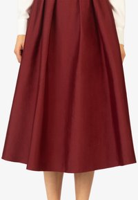 Gonna midi bordeaux con una texture liscia, design plissettato e silhouette svasata, ideale per un look formale o casual.
