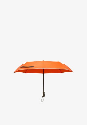 Compact orange umbrella opened with black handle and wrist strap, rectangular shape, black logo patch on canopy edge.