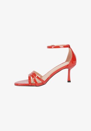 Sandal alta in vernice rossa con tacco, cinturino alla caviglia, design open-toe, tre cinturini frontali e un tacco sottile. Texture liscia.