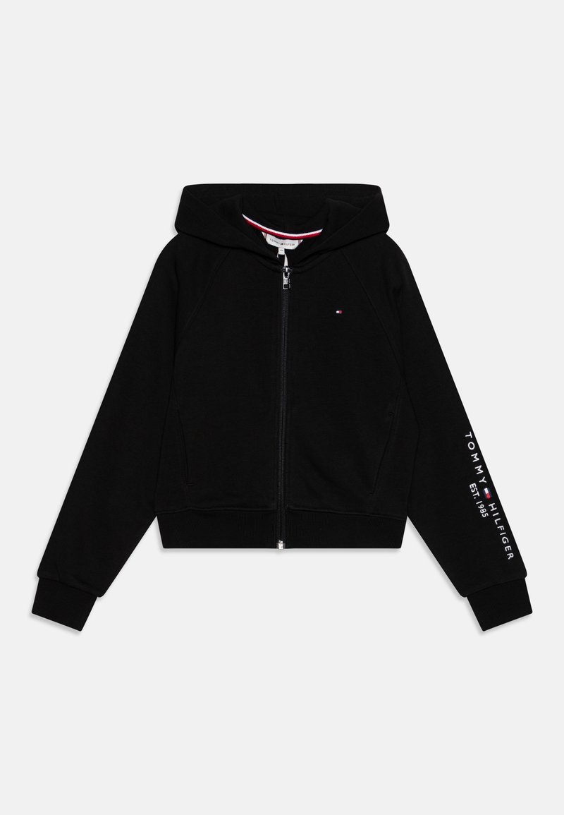 Sweat à capuche noir zippé en tissu doux, doté d'une capuche, de poignets côtelés et de l'inscription "TOMMY HILFIGER EST. 1985" imprimée en blanc sur la manche.
