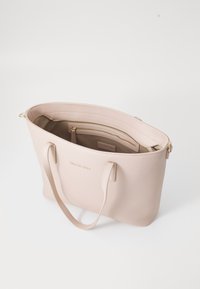 Rozā �ādas somiņa ar zelta furnitūru, plašu interjeru un vairākiem nodalījumiem. Aprīkota ar garām rokturiem un minimālistisku dizainu.