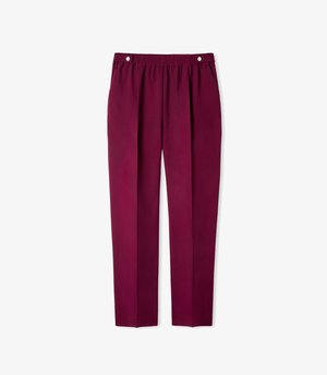 Pantaloni bordeaux realizzati in tessuto liscio, con vita elasticizzata, pieghe frontali e due tasche laterali. Design a pannello piatto.