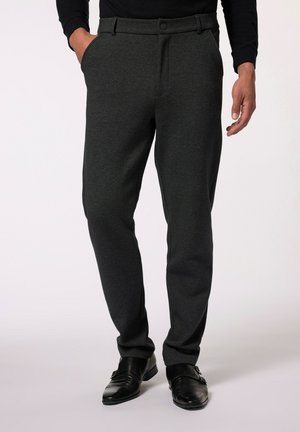 Pantalons ajustés gris foncé en tissu lisse, dotés d'un pli avant, de poches latérales et d'une fermeture par bouton, associés à des chaussures brillantes noires.