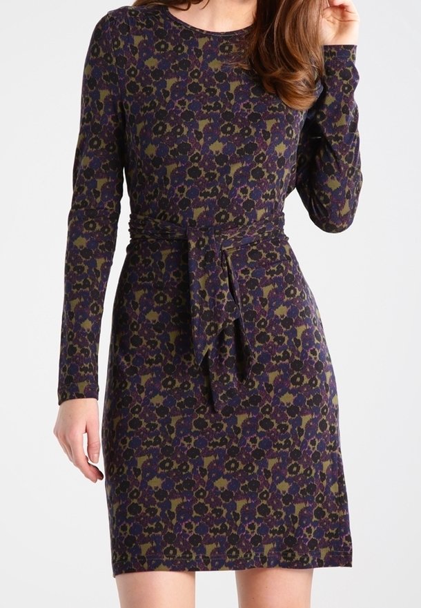 Długo rękawowa, dopasowana sukienka w ciemnofioletowym kolorze z kwiatowym nadrukiem w zieleni i żółci. Posiada paskiem do wiązania w talii oraz okrągły dekolt.