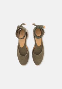 Groene canvas espadrilles met een aangeknoopte enkelband, open hiel en geweven jute accenten. Glad binnenmateriaal en ronde teenvorm.