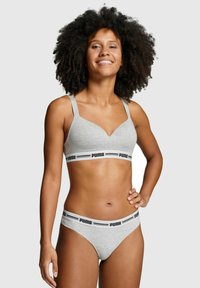 Grauer Baumwoll-Bralette mit verstellbaren Trägern und einem schwarzen, gebrandeten Bund, kombiniert mit passenden grauen Baumwoll-Bikini-Slips. Glatte Textur.