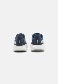 HOKA Arahi 7 running shoes in dark blue and white, featuring a padded collar, textured surface, and prominent branding on the heel.