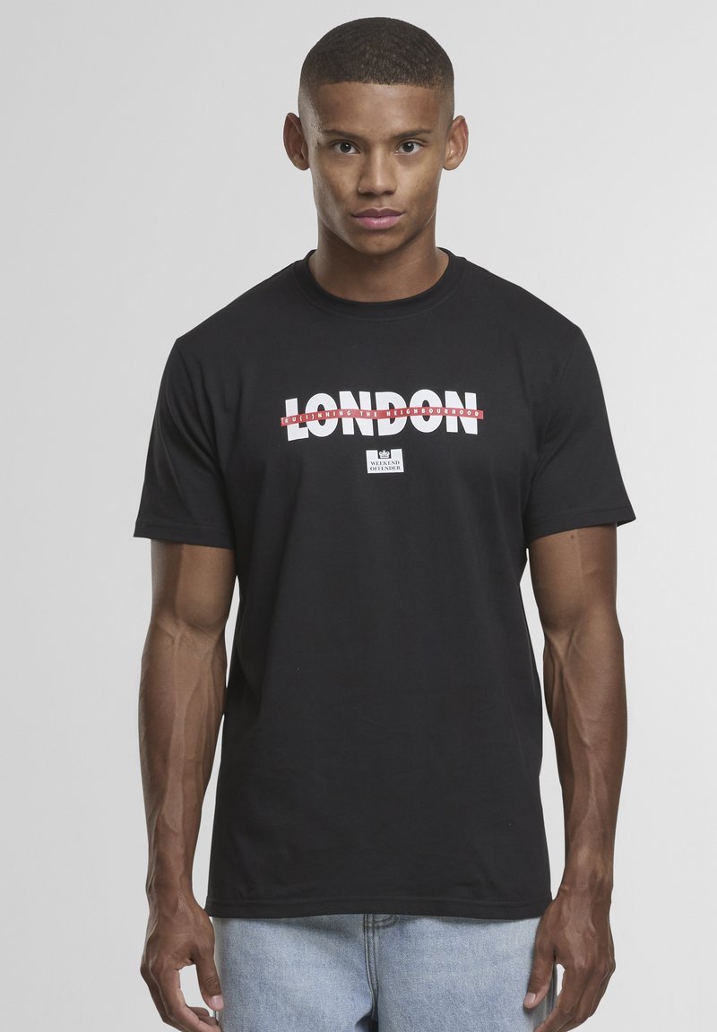 Zwart katoenen T-shirt met vetgedrukte witte tekst "LONDEN" met rode accenten. Ronde halslijn, korte mouwen en een standaard pasvorm. Casual stijl.