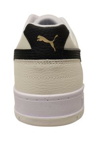 Sneaker bianca con un tallone in pelle nera texture, con un piccolo logo dorato. Parte superiore bianca liscia e suola in gomma, design minimal.