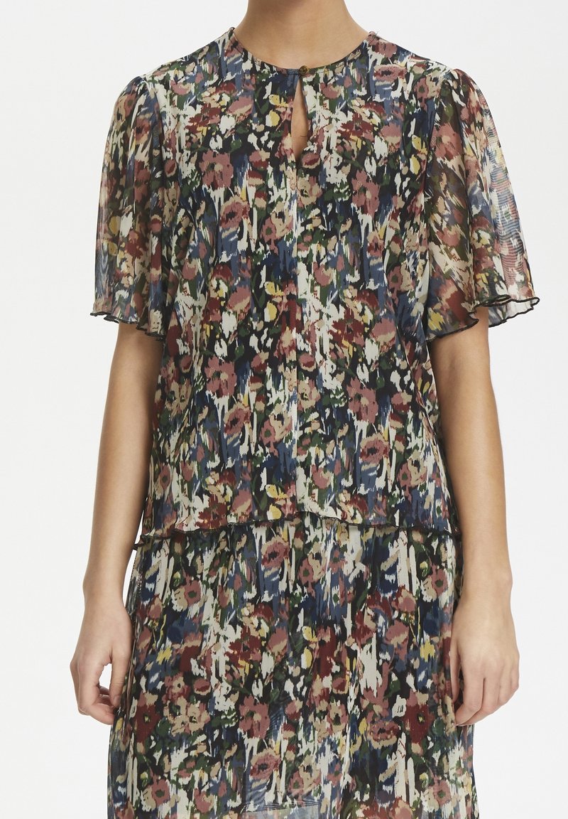 Blumenmuster Bluse aus semi-transparentem Stoff mit puffärmel, Schlüsselloch-Ausschnitt und mehrfarbigen Mustern in Rot-, Grün- und Blautönen.