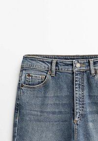 Lichtblauwe denim jeans met een rechte snit, vijf zakken, koperen klinknagels en een ritsgulp met knoopsluiting. Subtiele vervagingdetails.